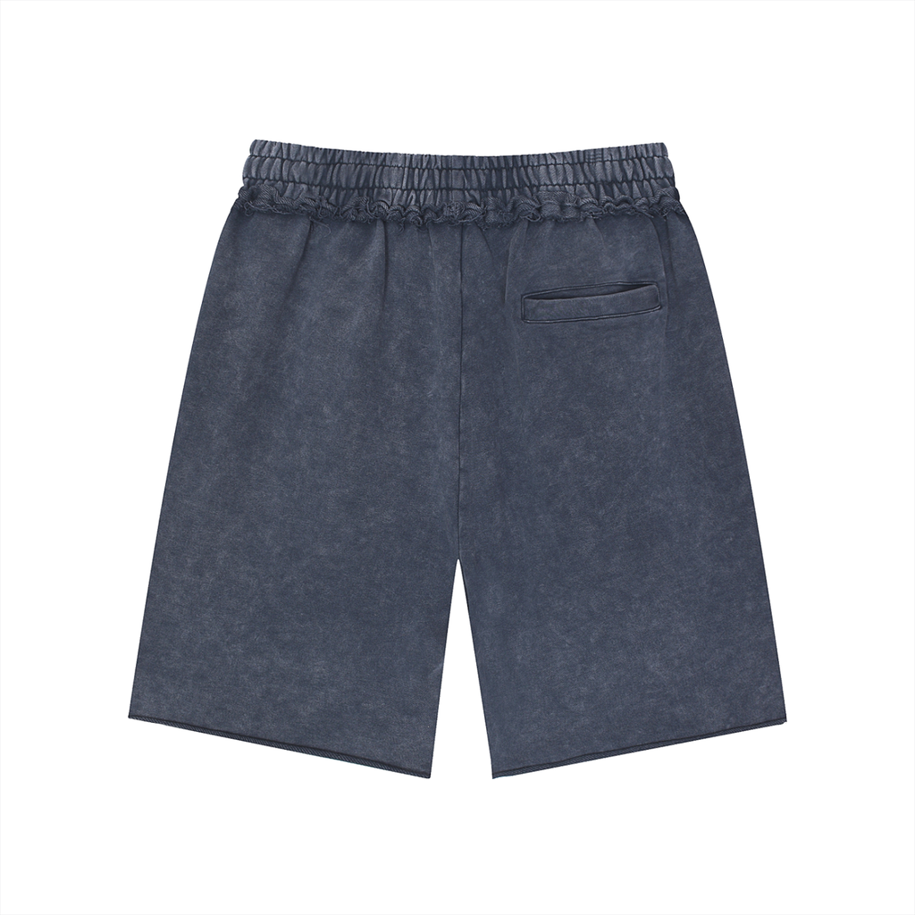Back view of Pensacola Shorts—loose, mid waist unisex cotton shorts in dark blue with an elastic waistband and single back pocket, vintage streetwear style—displayed on a plain white background.