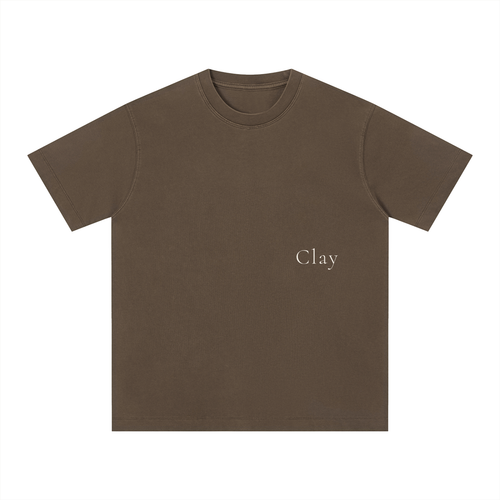 The Charleston Shirt is a loose fit unisex brown cotton t-shirt with "Clay" printed in small, light text on the left chest. This short sleeve tee is shown on a white background.