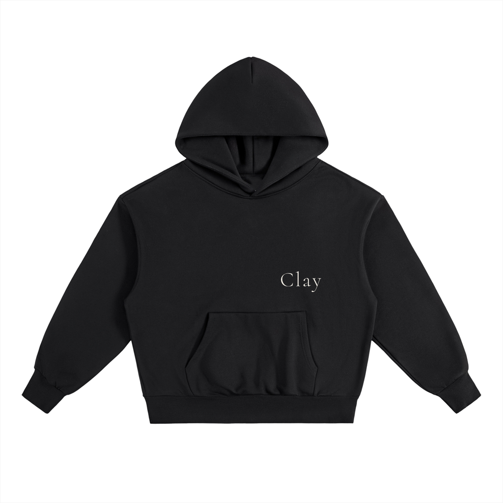 The Selma Hoodie is a black unisex, oversized hoodie made from a soft cotton blend with a front pocket. "Clay" is embroidered in small white text on the left chest. Shown laid flat on a white background.