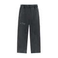 Nashville Sweatpants: Charcoal gray, loose-fit unisex cotton pants with an elastic waistband, side pockets, and a drawstring. "Clay" printed in white on the left thigh—streetwear style, shown laid flat on a white background.