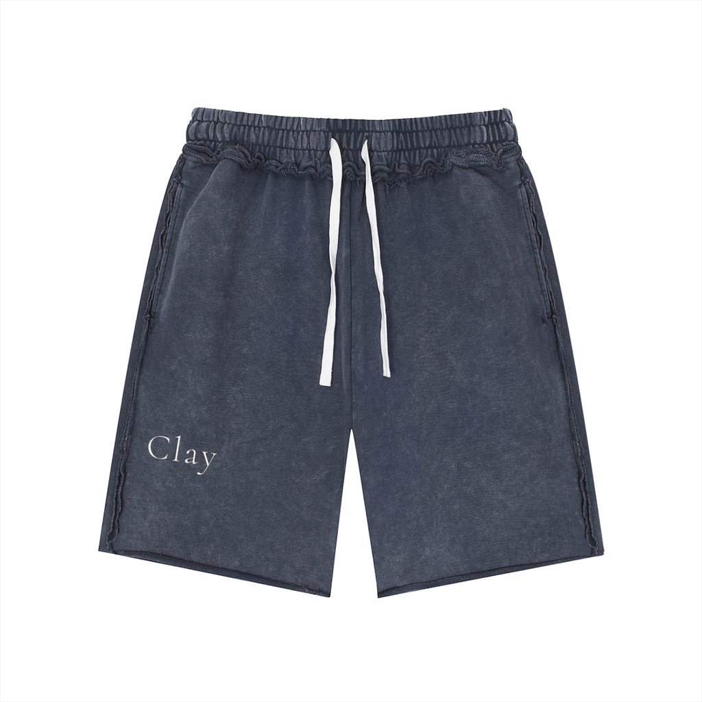 The Pensacola Shorts are dark gray unisex cotton shorts with a loose mid waist, elastic waistband, and "Clay" printed in white on the left leg for a vintage streetwear look.