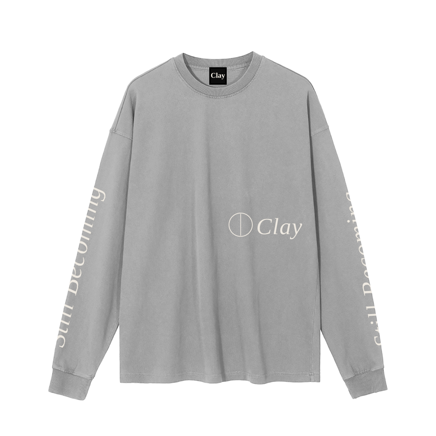 The Gatlinburg Long Sleeve T-Shirt is a gray crew neck with “Clay” and a circle logo on the chest. “Still Becoming” accents both sleeves in light text. This relaxed fit top is perfect for street style and everyday wear.