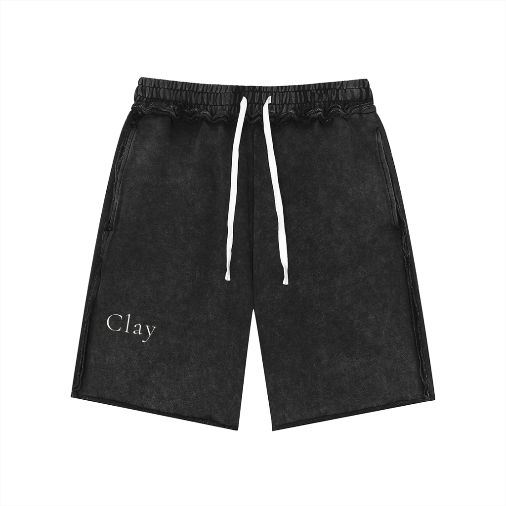 Pensacola Shorts: Black unisex cotton shorts with white drawstrings and "Clay" printed in white on the lower left leg, giving off a vintage streetwear style. Displayed on a plain white background.