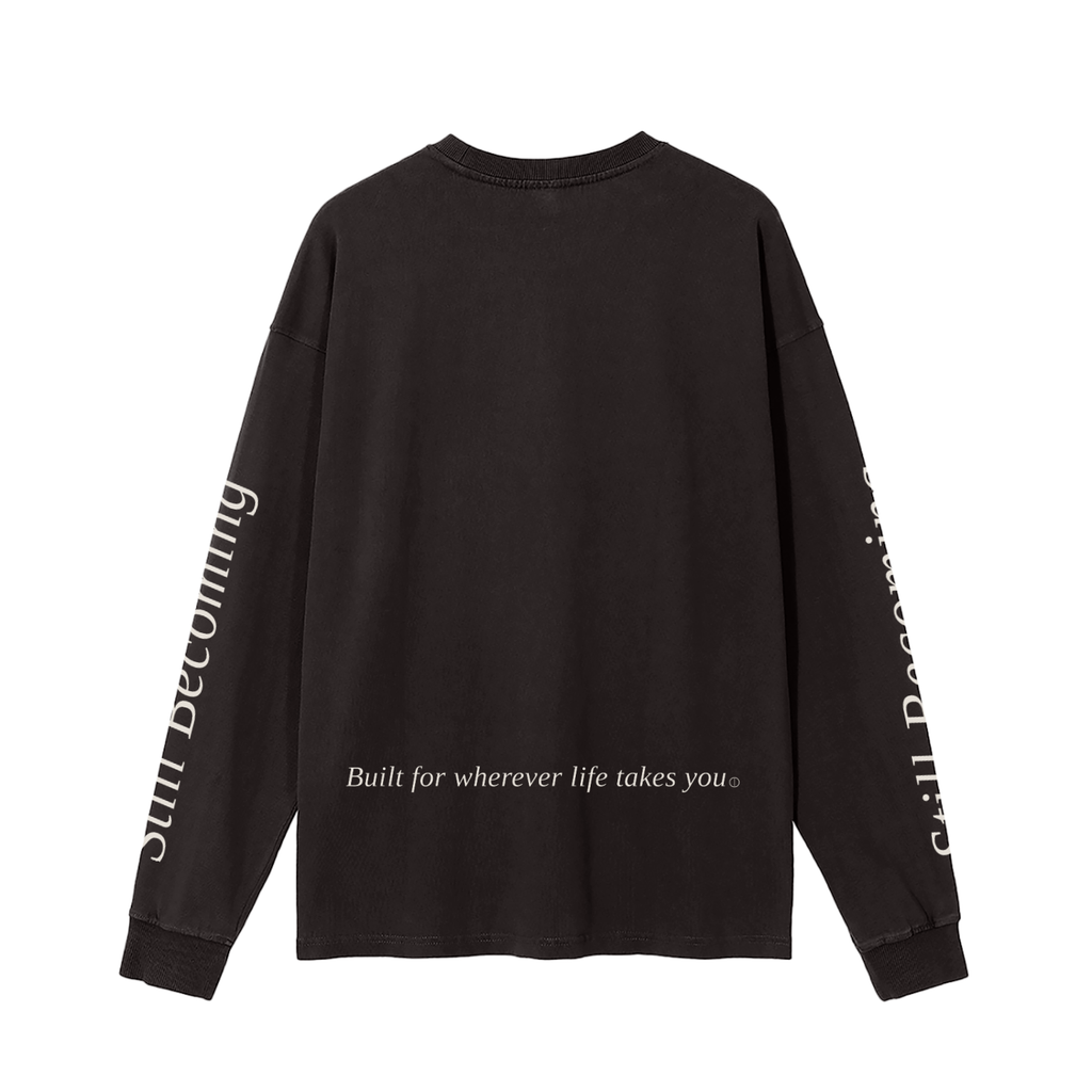 The Gatlinburg Long Sleeve T-Shirt is a unisex black cotton top with “Built for wherever life takes you” on the lower back and “Still Becoming” along the sleeves—perfect casual streetwear for autumn and winter.