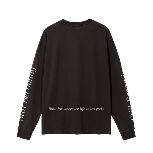 The Gatlinburg Long Sleeve T-Shirt is a unisex black cotton top with “Built for wherever life takes you” on the lower back and “Still Becoming” along the sleeves—perfect casual streetwear for autumn and winter.